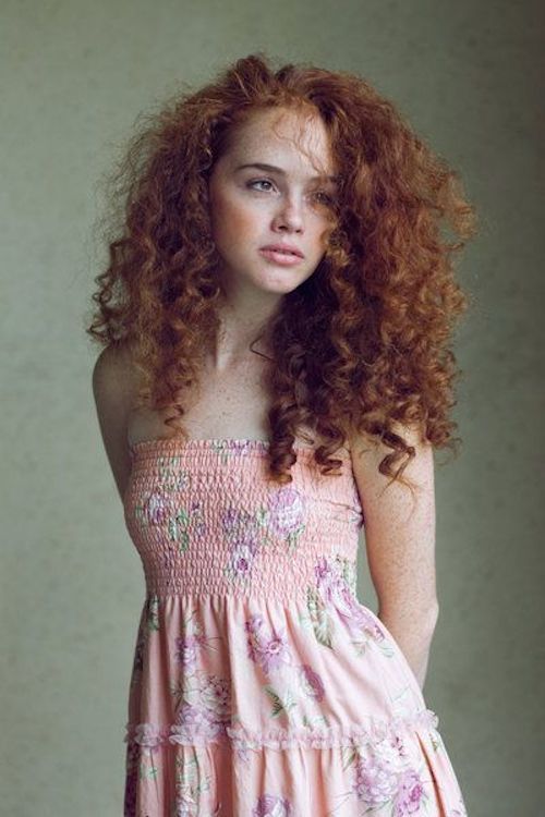 Not all redheads have light skin and blonde eyebrows/lashes. This redhead has deep features with curly red hair.