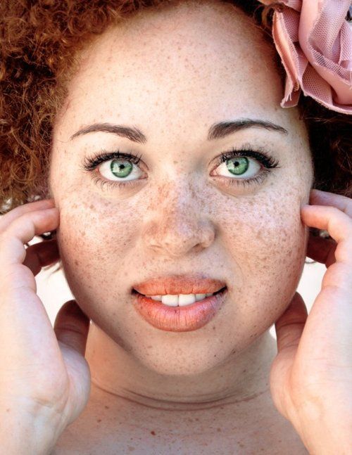 Beautiful woman with freckles and natural red hair of African American decent.